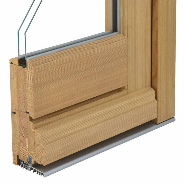 Der Querschnitt einer Holzhaustür zeigt einen hellen Holzrahmen, eine zweifach-Verglasung und eine Metallschwelle mit weißem Hintergrund.