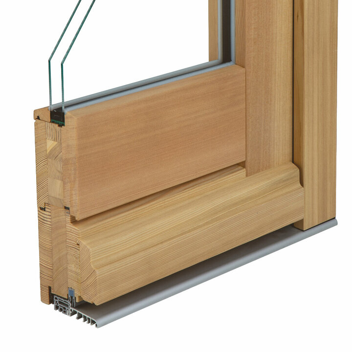 Der Querschnitt einer Holzhaustür zeigt einen hellen Holzrahmen, eine Glasscheibe und eine Metallschwelle mit weißem Hintergrund.