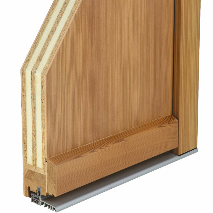 Eine klar lackierte Holztür mit weißer Dämmschicht wird schräg von oben gezeigt.