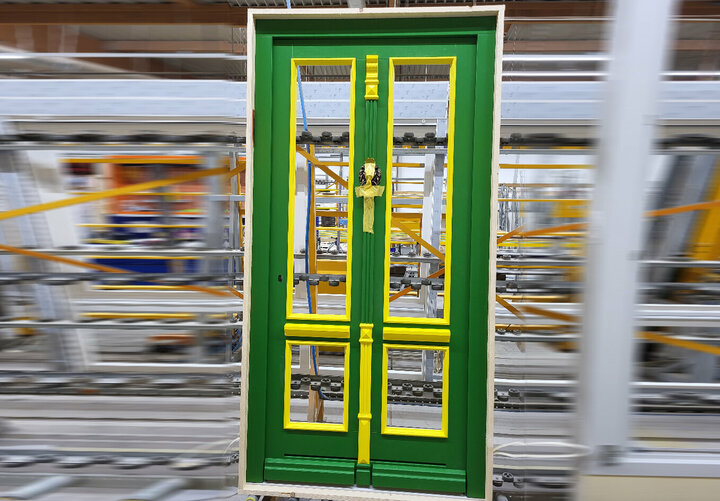 Eine grüne Tür mit gelben Akzenten ist in einem Lagerhaus ausgestellt.