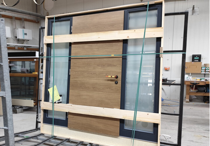 Eine für den Versand vorbereitete Haustür mit 2 Seitenteilen. Die Türrahmen sind Anthrazit und das Türblatt in Eiche astig natur