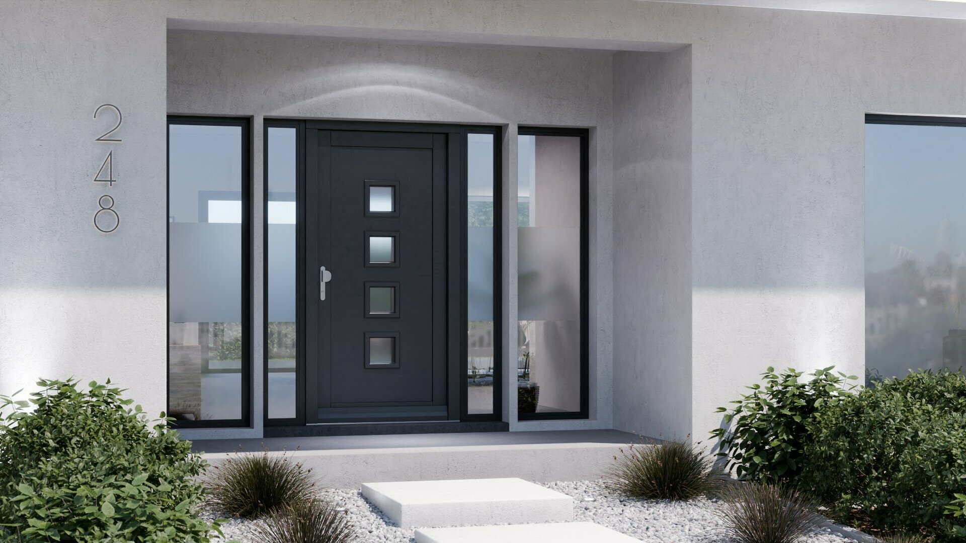 Ein modernes graues Haus mit einer schwarzen Eingangstür, die von zwei Fenstern flankiert wird, steht vor dem Hintergrund eines klaren blauen Himmels und üppig grüner Bäume.